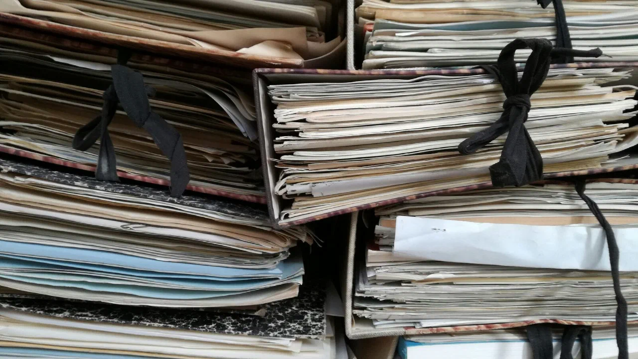 Rows of worn brown ring binders packed onto shelves