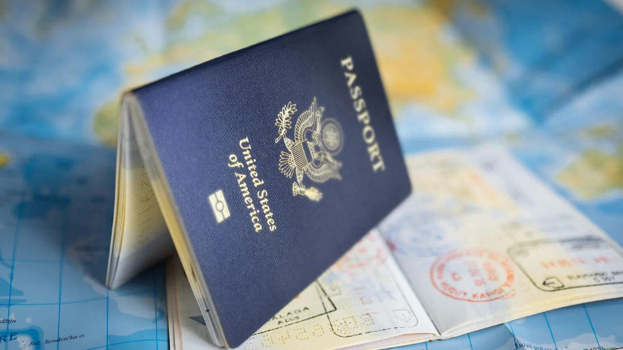A United States passport lying open on a printed world map