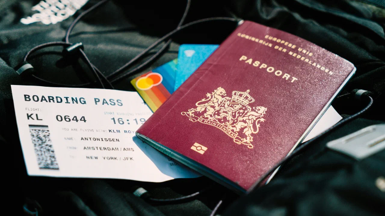 A passport and a boarding pass resting on a canvas bag